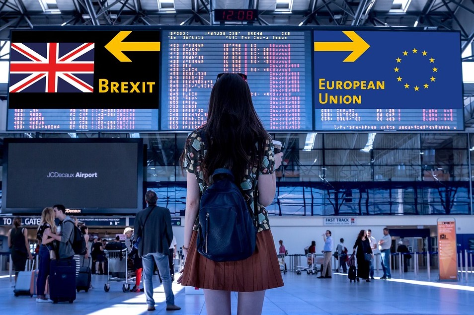 Girl looking at airport board with UK and EU flags